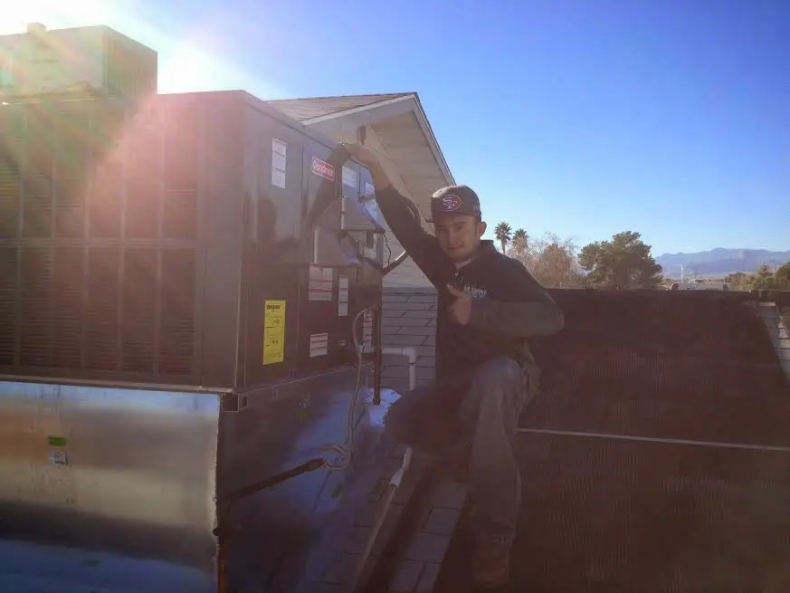 HVAC technician performing Air Duct Cleaning on a rooftop unit in Bristol